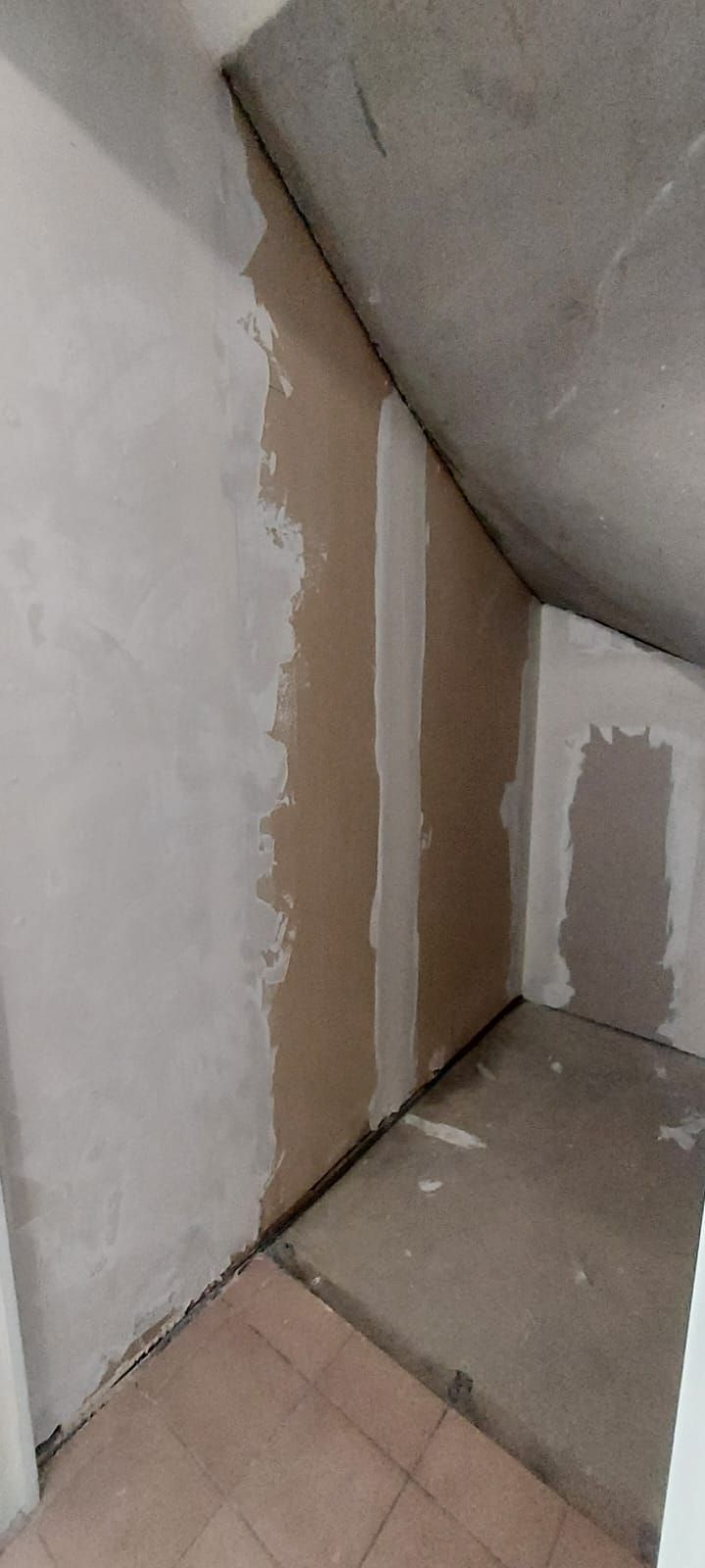 Avant travaux : dessous d'escalier aux murs bruts