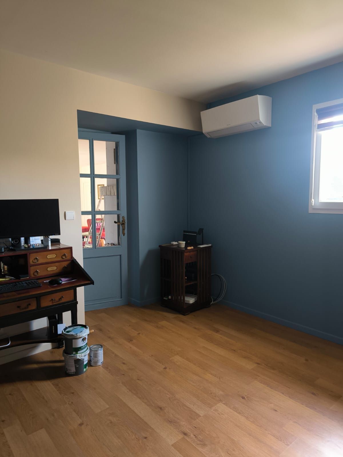 Bureau aux murs bleus avec un parquet en bois